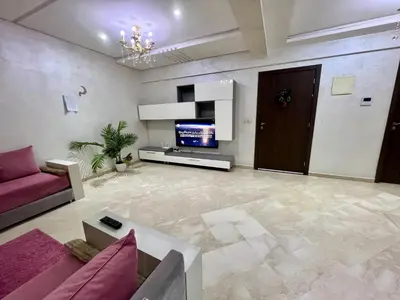 a living room with a couch and a tv at Rosa High standing apartment in Marrakech