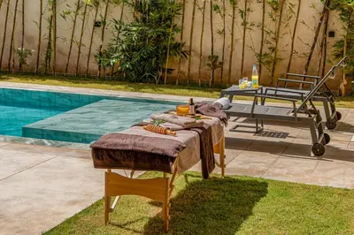 a table with a blanket next to a pool at Villa LUMA - Akenza Residence in El Rhechat