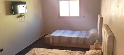 a small bedroom with a bed and a television at Belkadi in Marrakech