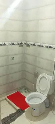 a bathroom with a toilet and a red rug at Belkadi in Marrakech