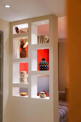 a wall with a white shelf with pictures on it at Victor Hugo Prestige Suite in Marrakech