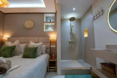 a bedroom with a bed with a shower and a mirror at Victor Hugo Prestige Suite in Marrakech