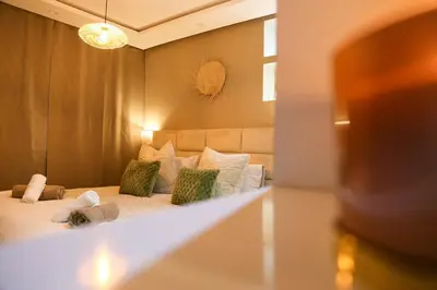 a bedroom with a bed with green and white pillows at Victor Hugo Prestige Suite in Marrakech
