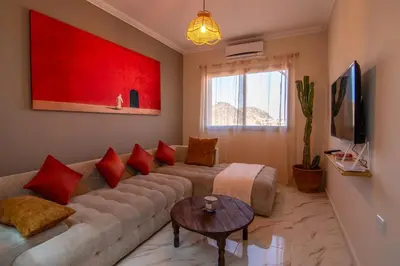 a living room with a couch and red pillows at Victor Hugo Prestige Suite in Marrakech