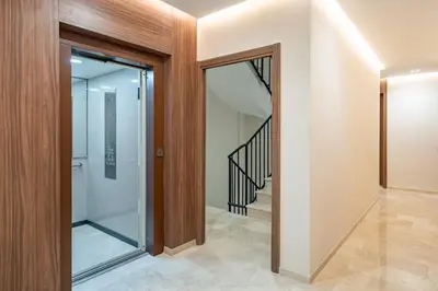 a glass pivot door in a hallway with a staircase at Appartement moderne en plein Gueliz in Marrakech