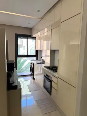 a kitchen with white cabinets and a large window at Appartement moderne en plein Gueliz in Marrakech