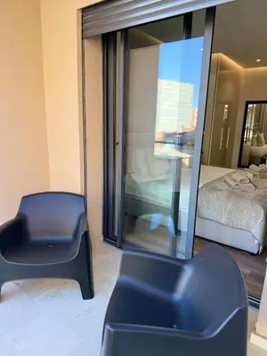 a room with a chair and a bed and a mirror at Appartement moderne en plein Gueliz in Marrakech
