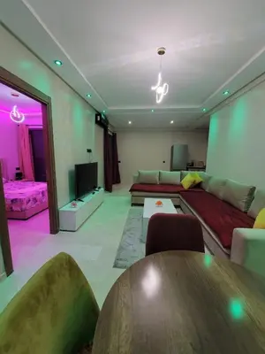 a living room with a couch and a table at Nour prestige Appartement Piscine free Parking in Marrakech