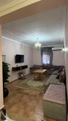 a living room with a couch and a table at Appartement 2 chambres et 1 salon récemment rénové in Marrakech