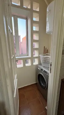 a laundry room with a washing machine and a window at Appartement 2 chambres et 1 salon récemment rénové in Marrakech