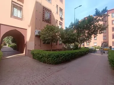 a building with an archway next to a sidewalk at Appartement 2 chambres et 1 salon récemment rénové in Marrakech