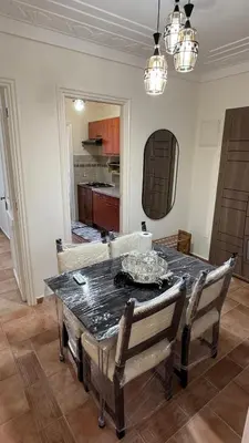 a dining room with a table and a couch at Appartement 2 chambres et 1 salon récemment rénové in Marrakech