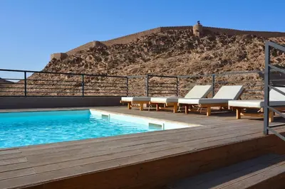 a swimming pool with lounge chairs and a hill at Studio luxueux - centre ville in Marrakech