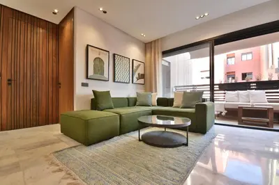 a living room with a green couch and a table at Studio luxueux - centre ville in Marrakech