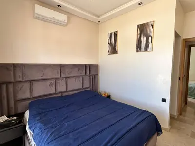 a bedroom with a bed with a blue blanket at Villa l'odyssée in Marrakech