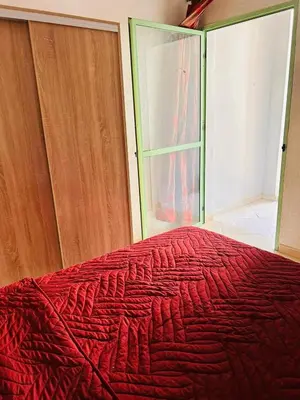 a bedroom with a bed with a red blanket at Quiet &Bright Apartment in Marrakech