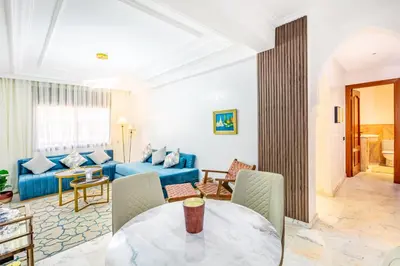 a living room with a blue couch and a table at Perle Soft light and air conditioning in Marrakech