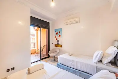 a bedroom with two beds and a window at Perle Soft light and air conditioning in Marrakech