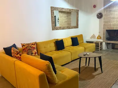 a yellow couch in a living room with a table at Villa Bellisa in Marrakech