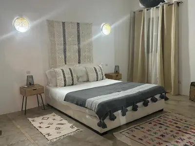 a bedroom with a bed with two night stands and two lamps at Villa Bellisa in Marrakech