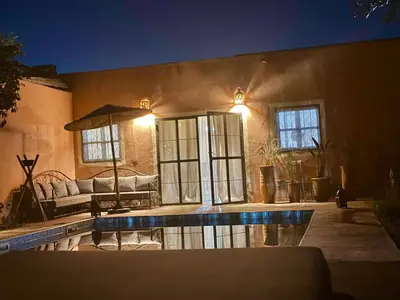 a living room with a couch and a swimming pool at Villa Bellisa in Marrakech