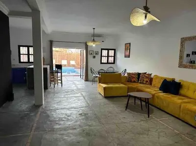 a living room with a yellow couch and a table at Villa Bellisa in Marrakech