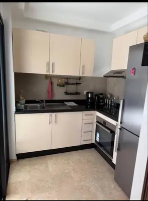 a kitchen with white cabinets and a stainless steel refrigerator at Marrakech Peaceful Escape - Appartement Noria Marrakech in Marrakech