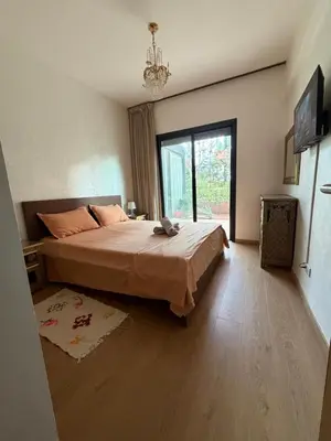 a bedroom with a large bed and a large window at Marrakech Peaceful Escape - Appartement Noria Marrakech in Marrakech