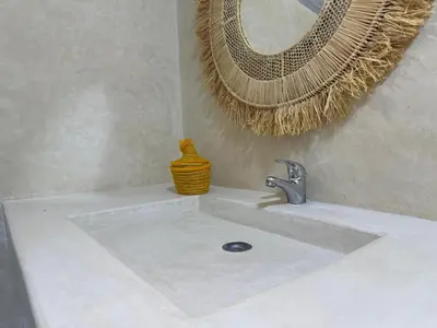 a bathroom sink with a faucet and a mirror at Villa Lalla et Moulay in Marrakech