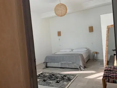 a bedroom with a bed in a white room at Villa Lalla et Moulay in Marrakech