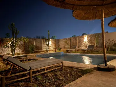 a swimming pool with an umbrella and a chaise lounge and sidx sidx at Villa Lalla et Moulay in Marrakech