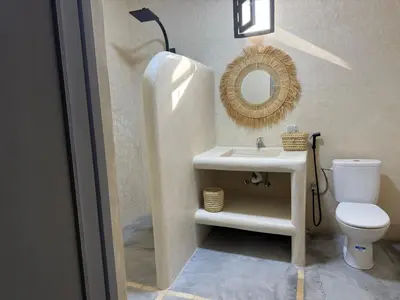 a bathroom with a sink and a toilet and a mirror at Villa Lalla et Moulay in Marrakech