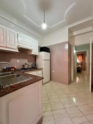 a kitchen with white cabinets and a tile floor at Appartement allal el fassi in Marrakech