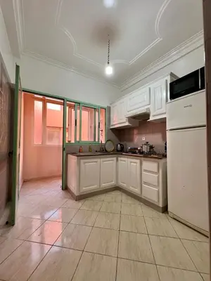a kitchen with white cabinets and a white refrigerator at Appartement allal el fassi in Marrakech