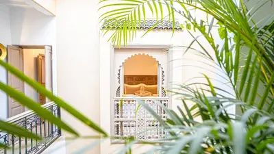 a house with a balcony with plants in the foreground at Riad Lalla Sofia à 200m des tombeaux Saadiens in Marrakech