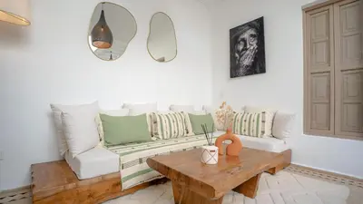 a living room with a couch and a wooden table at Riad Lalla Sofia à 200m des tombeaux Saadiens in Marrakech
