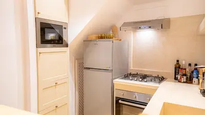 a kitchen with a white refrigerator and a stove at Riad Lalla Sofia à 200m des tombeaux Saadiens in Marrakech
