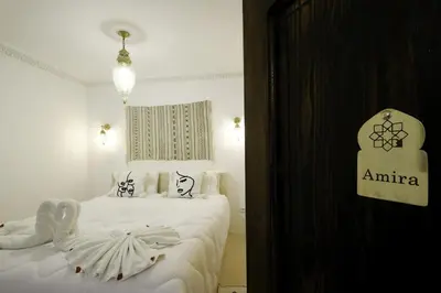 a bedroom with two beds and a sign that says amaria at Riad Armonia in Marrakech