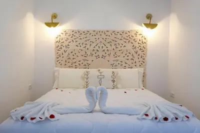 a bedroom with a white bed with a white headboard at Riad Armonia in Marrakech