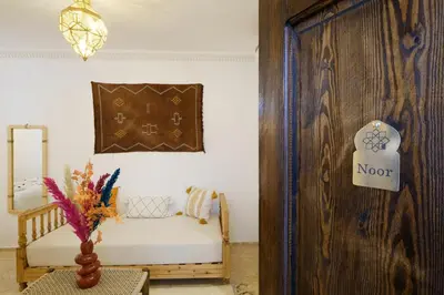 a room with a couch and a wooden door at Riad Armonia in Marrakech