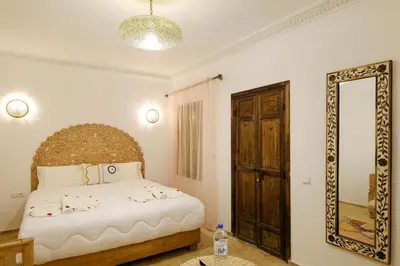 a bedroom with a large bed and a mirror at Riad Armonia in Marrakech