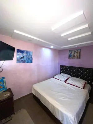 a bedroom with a bed and a pink wall at Dar Hiba in Marrakech