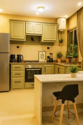 a kitchen with yellow cabinets and a black chair in it at Marrakech Menara in Marrakech