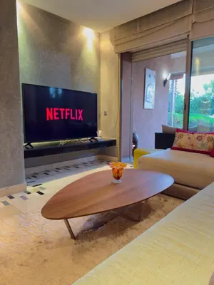 a living room with a television and a coffee table at VIVASTAY Marrakech - Prestigia Topaze- Terrace overlooking garden & pool in Marrakech