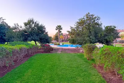 a yard with a swimming pool and trees at VIVASTAY Marrakech - Prestigia Topaze- Terrace overlooking garden & pool in Marrakech