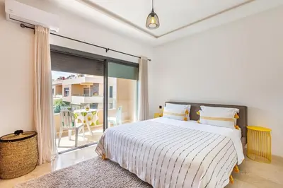 a white bedroom with a bed and a balcony at Villa Gina, Piscine, Terasse, 15 min du centre in Marrakech