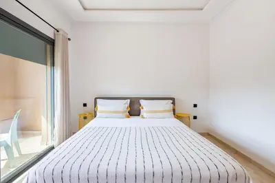a white bed in a room with a window at Villa Gina, Piscine, Terasse, 15 min du centre in Marrakech