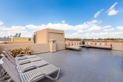 a patio with white lounge chairs on a roof at Villa Gina, Piscine, Terasse, 15 min du centre in Marrakech