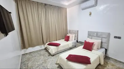 two beds with red pillows in a room at Villa à marrakech in Marrakech