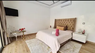 a bedroom with a large bed with pink pillows on it at Villa à marrakech in Marrakech